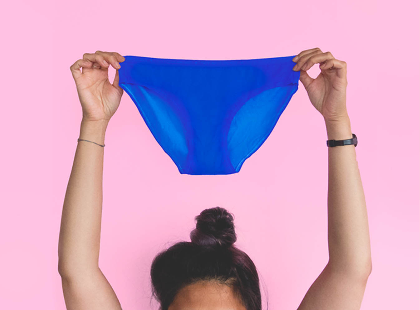 Girls arms holding up blue underwear